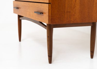 Teak chest of drawers by V-form (Belgium, 1960s). This elegant chest of drawers featured four drawers with black metal handles on them and stands on a nicely organic shaped frame. It has a beautiful natural woodgrain and has convenient dimensions. In good condition with some normal wear and tear.