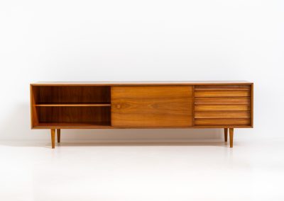 Teak low sideboard from the Platon series by Lothar Wegner (Germany, 1960s). It features two big sliding doors, three drawers and lots of storage space. The combination of the sleek lines and the organic drawers is just amazing. It has subtle round inset handles and a beautiful warm woodgrain. It has some color difference on the top and one of the handles is a little damaged. Otherwise, it is in beautiful condition!