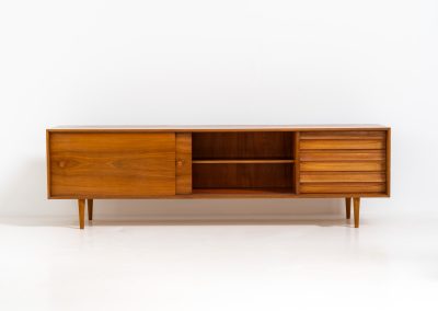 Teak low sideboard from the Platon series by Lothar Wegner (Germany, 1960s). It features two big sliding doors, three drawers and lots of storage space. The combination of the sleek lines and the organic drawers is just amazing. It has subtle round inset handles and a beautiful warm woodgrain. It has some color difference on the top and one of the handles is a little damaged. Otherwise, it is in beautiful condition!