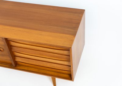 Teak low sideboard from the Platon series by Lothar Wegner (Germany, 1960s). It features two big sliding doors, three drawers and lots of storage space. The combination of the sleek lines and the organic drawers is just amazing. It has subtle round inset handles and a beautiful warm woodgrain. It has some color difference on the top and one of the handles is a little damaged. Otherwise, it is in beautiful condition!