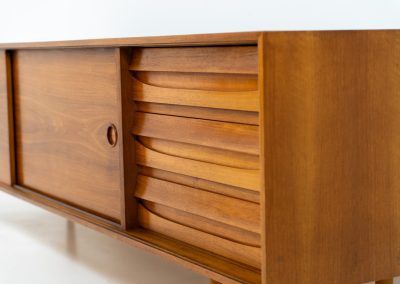Teak low sideboard from the Platon series by Lothar Wegner (Germany, 1960s). It features two big sliding doors, three drawers and lots of storage space. The combination of the sleek lines and the organic drawers is just amazing. It has subtle round inset handles and a beautiful warm woodgrain. It has some color difference on the top and one of the handles is a little damaged. Otherwise, it is in beautiful condition!