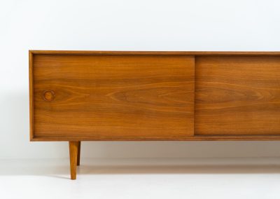 Teak low sideboard from the Platon series by Lothar Wegner (Germany, 1960s). It features two big sliding doors, three drawers and lots of storage space. The combination of the sleek lines and the organic drawers is just amazing. It has subtle round inset handles and a beautiful warm woodgrain. It has some color difference on the top and one of the handles is a little damaged. Otherwise, it is in beautiful condition!