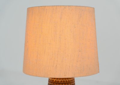 Handmade ceramic table lamp by Einar Johansen for Søholm Stentøj (Denmark, 1960s). This beautiful piece was designed by Einar Johansen and hand made on the Danish island of Bornholm by the company Søholm Stentøj. It features a beautiful graphic pattern with lots of details on the base and a large hessian lamp shade. In very good and original condition.