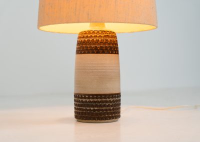 Handmade ceramic table lamp by Einar Johansen for Søholm Stentøj (Denmark, 1960s). This beautiful piece was designed by Einar Johansen and hand made on the Danish island of Bornholm by the company Søholm Stentøj. It features a beautiful graphic pattern with lots of details on the base and a large hessian lamp shade. In very good and original condition.