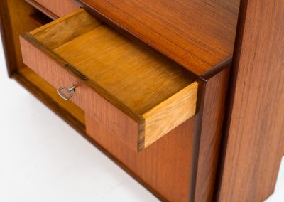 Teak shelving system / room devider (Sweden, 1960s). A very nice piece featuring two sliding doors, two drawers and three adjustable shelves. It’s sleek minimalist design combined with a wonderful warm woodgrain are a perfect match. With its finished back, this versatile piece can be used as a room divider aswell, making it a perfect addition to any space. In excellent condition! Comes with the original keys.