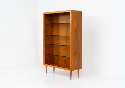 Teak showcase by Svend Dyrlund (Denmark, 1960s). A nice piece with organic shapes and four glass shelves. It has two functional lights on the inside. It is in very good condition.