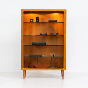 Teak showcase by Svend Dyrlund (Denmark, 1960s). A nice piece with organic shapes and four glass shelves. It has two functional lights on the inside. It is in very good condition.