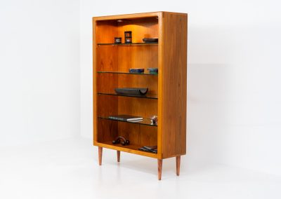 Teak showcase by Svend Dyrlund (Denmark, 1960s). A nice piece with organic shapes and four glass shelves. It has two functional lights on the inside. It is in very good condition.