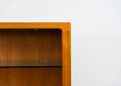 Teak showcase by Svend Dyrlund (Denmark, 1960s). A nice piece with organic shapes and four glass shelves. It has two functional lights on the inside. It is in very good condition.
