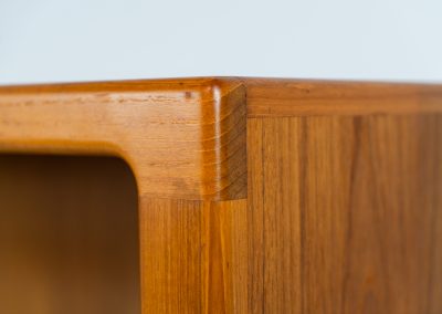 Teak showcase by Svend Dyrlund (Denmark, 1960s). A nice piece with organic shapes and four glass shelves. It has two functional lights on the inside. It is in very good condition.