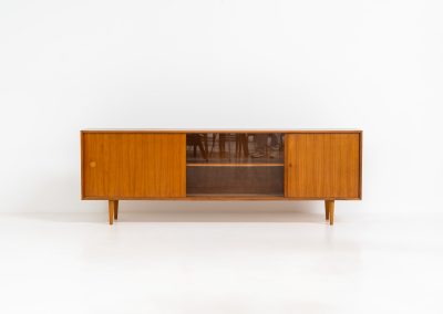 Teak sideboard by Lothar Wegner (Germany, 1960s). It features a teak sliding door, a glass sliding door and a smaller door with a lock and shelves on the inside. A sleek and stylish piece, presented in very good condition.