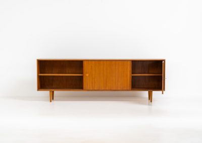 Teak sideboard by Lothar Wegner (Germany, 1960s). It features a teak sliding door, a glass sliding door and a smaller door with a lock and shelves on the inside. A sleek and stylish piece, presented in very good condition.