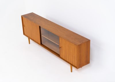 Teak sideboard by Lothar Wegner (Germany, 1960s). It features a teak sliding door, a glass sliding door and a smaller door with a lock and shelves on the inside. A sleek and stylish piece, presented in very good condition.