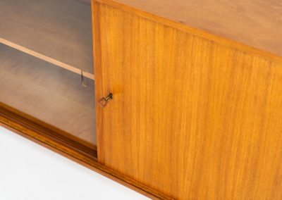 Teak sideboard by Lothar Wegner (Germany, 1960s). It features a teak sliding door, a glass sliding door and a smaller door with a lock and shelves on the inside. A sleek and stylish piece, presented in very good condition.