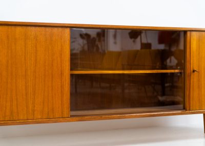 Teak sideboard by Lothar Wegner (Germany, 1960s). It features a teak sliding door, a glass sliding door and a smaller door with a lock and shelves on the inside. A sleek and stylish piece, presented in very good condition.