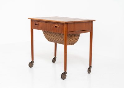 Teak sewing box side table on castors (Denmark, 1960s). This little beauty features a drawer and a wicker basket that can be slid out from both sides. It’s in good condition with some small repair marks.
