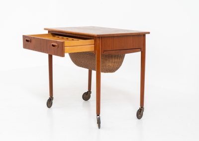 Teak sewing box side table on castors (Denmark, 1960s). This little beauty features a drawer and a wicker basket that can be slid out from both sides. It’s in good condition with some small repair marks.