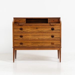 Rosewood secretary by Borge Hansen for Riis Antonsen (Denmark, 1950s). A very elegant piece containing three main drawers, two small drawers and a convenient pull-out leaf. It has very nice details and a mesmerizing woodgrain. The secretary is in very good condition with a few using traces related to its age. Marked by maker. Original key included.