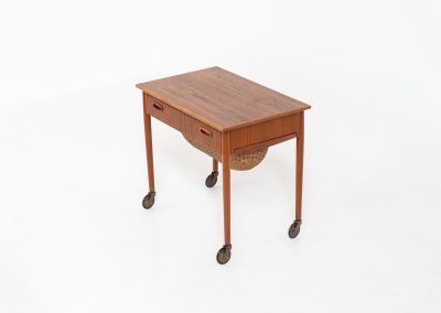 Teak sewing box side table on castors (Denmark, 1960s). This little beauty features a drawer and a wicker basket that can be slid out from both sides. It’s in good condition with some small repair marks.