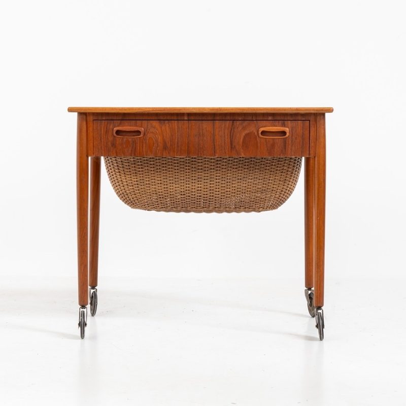 Teak sewing box side table on castors (Denmark, 1960s). This little beauty features a drawer and a wicker basket that can be slid out from both sides. It’s in good condition with some small repair marks.