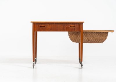 Teak sewing box side table on castors (Denmark, 1960s). This little beauty features a drawer and a wicker basket that can be slid out from both sides. It’s in good condition with some small repair marks.