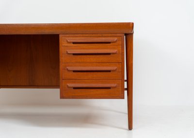 Rare executive writing desk by Ib Kofod Larsen for Faarup (Denmark, 1960s). This huge and absolutely gorgeous piece is one of the highest-quality desks we’ve come across, with an incredible attention to detail! Featuring a spacious desktop with a beautiful woodgrain, two cabinets with locks and an open shelve on the backside, two pull/out leafs and six big drawers on the frontside. Two of the drawers can be securely locked with cleverly hidden locks on the inside. The desk is double sided which makes it a stunning piece to place in the center of a room. This piece presents itself in very good condition. All drawers, doors & locks function very smoothly! It can be easily disassembled for transport or storage.