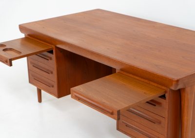 Rare executive writing desk by Ib Kofod Larsen for Faarup (Denmark, 1960s). This huge and absolutely gorgeous piece is one of the highest-quality desks we’ve come across, with an incredible attention to detail! Featuring a spacious desktop with a beautiful woodgrain, two cabinets with locks and an open shelve on the backside, two pull/out leafs and six big drawers on the frontside. Two of the drawers can be securely locked with cleverly hidden locks on the inside. The desk is double sided which makes it a stunning piece to place in the center of a room. This piece presents itself in very good condition. All drawers, doors & locks function very smoothly! It can be easily disassembled for transport or storage.