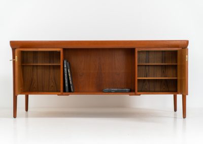 Rare executive writing desk by Ib Kofod Larsen for Faarup (Denmark, 1960s). This huge and absolutely gorgeous piece is one of the highest-quality desks we’ve come across, with an incredible attention to detail! Featuring a spacious desktop with a beautiful woodgrain, two cabinets with locks and an open shelve on the backside, two pull/out leafs and six big drawers on the frontside. Two of the drawers can be securely locked with cleverly hidden locks on the inside. The desk is double sided which makes it a stunning piece to place in the center of a room. This piece presents itself in very good condition. All drawers, doors & locks function very smoothly! It can be easily disassembled for transport or storage.