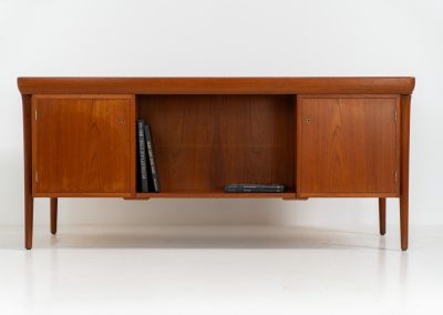 Rare executive writing desk by Ib Kofod Larsen for Faarup (Denmark, 1960s). This huge and absolutely gorgeous piece is one of the highest-quality desks we’ve come across, with an incredible attention to detail! Featuring a spacious desktop with a beautiful woodgrain, two cabinets with locks and an open shelve on the backside, two pull/out leafs and six big drawers on the frontside. Two of the drawers can be securely locked with cleverly hidden locks on the inside. The desk is double sided which makes it a stunning piece to place in the center of a room. This piece presents itself in very good condition. All drawers, doors & locks function very smoothly! It can be easily disassembled for transport or storage.