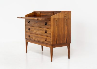 Rosewood secretary by Borge Hansen for Riis Antonsen (Denmark, 1950s). A very elegant piece containing three main drawers, two small drawers and a convenient pull-out leaf. It has very nice details and a mesmerizing woodgrain. The secretary is in very good condition with a few using traces related to its age. Marked by maker. Original key included.