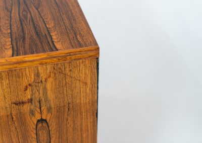 Rosewood secretary by Borge Hansen for Riis Antonsen (Denmark, 1950s). A very elegant piece containing three main drawers, two small drawers and a convenient pull-out leaf. It has very nice details and a mesmerizing woodgrain. The secretary is in very good condition with a few using traces related to its age. Marked by maker. Original key included.