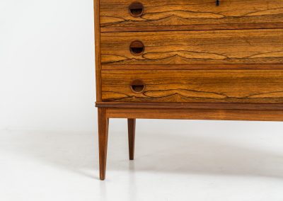 Rosewood secretary by Borge Hansen for Riis Antonsen (Denmark, 1950s). A very elegant piece containing three main drawers, two small drawers and a convenient pull-out leaf. It has very nice details and a mesmerizing woodgrain. The secretary is in very good condition with a few using traces related to its age. Marked by maker. Original key included.