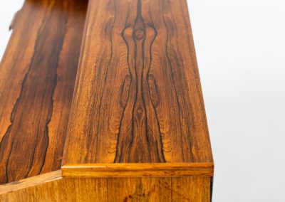 Rosewood secretary by Borge Hansen for Riis Antonsen (Denmark, 1950s). A very elegant piece containing three main drawers, two small drawers and a convenient pull-out leaf. It has very nice details and a mesmerizing woodgrain. The secretary is in very good condition with a few using traces related to its age. Marked by maker. Original key included.