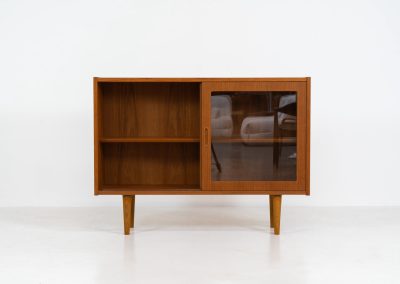 Display cabinet by Poul Hundevad (Denmark, 1960s). A convenient little piece featuring two sliding doors with a glass panel in them, and two adjustable shelves on the inside. In perfect condition and marked by maker.