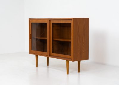 Display cabinet by Poul Hundevad (Denmark, 1960s). A convenient little piece featuring two sliding doors with a glass panel in them, and two adjustable shelves on the inside. In perfect condition and marked by maker.