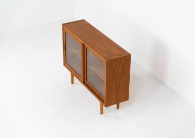 Display cabinet by Poul Hundevad (Denmark, 1960s). A convenient little piece featuring two sliding doors with a glass panel in them, and two adjustable shelves on the inside. In perfect condition and marked by maker.