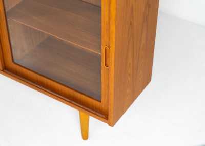 Display cabinet by Poul Hundevad (Denmark, 1960s). A convenient little piece featuring two sliding doors with a glass panel in them, and two adjustable shelves on the inside. In perfect condition and marked by maker.