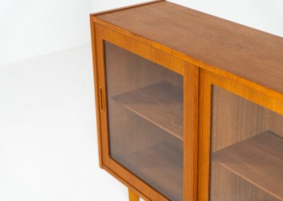 Display cabinet by Poul Hundevad (Denmark, 1960s). A convenient little piece featuring two sliding doors with a glass panel in them, and two adjustable shelves on the inside. In perfect condition and marked by maker.