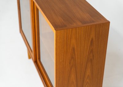 Display cabinet by Poul Hundevad (Denmark, 1960s). A convenient little piece featuring two sliding doors with a glass panel in them, and two adjustable shelves on the inside. In perfect condition and marked by maker.