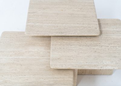 Set of 3 travertine nesting tables (Italy, 1970s). This gorgeous set, crafted in Italy, showcases a beautiful coarse grain that highlights the natural beauty of the stone. This clean and minimalistic design allows for versatile styling, offering endless combinations for various spaces. The tables are in excellent condition, free from cracks, chips or any damage.