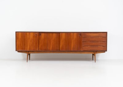 Paola sideboard by Oswald Vermaercke for V-Form (Belgium, 1959). An amazing design with a lot of details and a highly sought after dimensions. Featuring one folding door, two sliding doors and four drawers with beautifully curved bentwood interiors. It’s made out of teak and stands on an oak frame. While it has been restored, it still shows signs of its history, with visible use marks and some veneer patches from repairs. Given its age, it remains in good vintage condition.