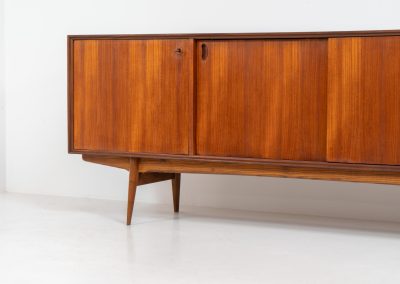 Paola sideboard by Oswald Vermaercke for V-Form (Belgium, 1959). An amazing design with a lot of details and a highly sought after dimensions. Featuring one folding door, two sliding doors and four drawers with beautifully curved bentwood interiors. It’s made out of teak and stands on an oak frame. While it has been restored, it still shows signs of its history, with visible use marks and some veneer patches from repairs. Given its age, it remains in good vintage condition.