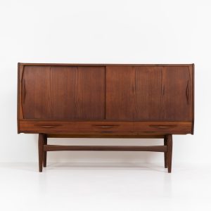 Teak highboard by Jensen & Mølholm (Denmark, 1960s). This stunning piece features two large sliding doors, three drawers, and lots of internal storage with three adjustable shelves and two small drawers. Crafted from warm, natural-looking teak, it showcases beautiful organic curves and elegant bent plywood handles. It is in very good condition with mild age marks and a little color difference on the left panel, as shown on the picture