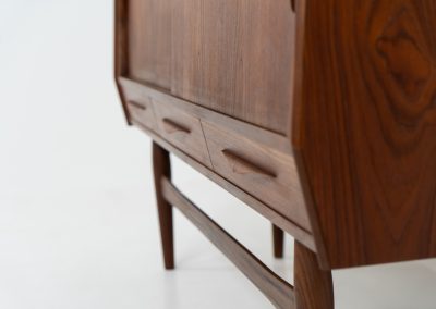 Teak highboard by Jensen & Mølholm (Denmark, 1960s). This stunning piece features two large sliding doors, three drawers, and lots of internal storage with three adjustable shelves and two small drawers. Crafted from warm, natural-looking teak, it showcases beautiful organic curves and elegant bent plywood handles. It is in very good condition with mild age marks and a little color difference on the left panel, as shown on the picture