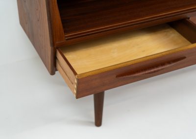 Teak highboard by Jensen & Mølholm (Denmark, 1960s). This stunning piece features two large sliding doors, three drawers, and lots of internal storage with three adjustable shelves and two small drawers. Crafted from warm, natural-looking teak, it showcases beautiful organic curves and elegant bent plywood handles. It is in very good condition with mild age marks and a little color difference on the left panel, as shown on the picture