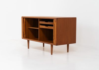 Svend Dyrlund teak sideboard with tambour doors (Denmark, 1960s). A wonderful sideboard with sought after dimensions. It perfectly combines very organic shapes and loads of detail, like the tambour sliding doors and the beautiful handles. It offers lots of storage space with an adjustable shelve and two drawers on the inside. An ideal piece for storing a record player and vinyls. Except for a little color difference on the top, this piece is in mint condition.