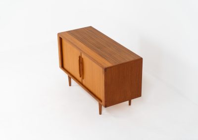 Svend Dyrlund teak sideboard with tambour doors (Denmark, 1960s). A wonderful sideboard with sought after dimensions. It perfectly combines very organic shapes and loads of detail, like the tambour sliding doors and the beautiful handles. It offers lots of storage space with an adjustable shelve and two drawers on the inside. An ideal piece for storing a record player and vinyls. Except for a little color difference on the top, this piece is in mint condition.