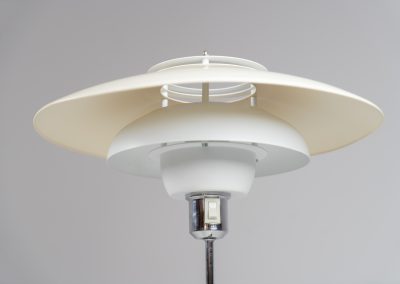 Danish table lamp, 1970s. We don’t know who made this one, but it is clearly inspired by Louis Poulsen’s work. The lamp is easy adjustable in highly with a chrome wheel. It’s made out of white lacquered metal with chrome details. It is in good vintage condition. The shade is not perfectly aligned anymore and the lacquer has some small color differences.