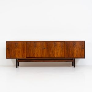 Rare XL sideboard in rosewood by Ib Kofod-Larsen for Faarup (Denmark, 1950s). This piece exudes pure luxury, featuring four large sliding doors with amazing inset handles and lots of storage space with adjustable drawers and shelves inside. The exterior is crafted from rosewood with a glossy finish, showcasing a stunning woodgrain, while the oak-finished interior provides a beautiful contrast. This hard to find piece presents itself in amazing vintage condition with minimal sings of a previous life. The doors slide really smooth. Marked by maker.
