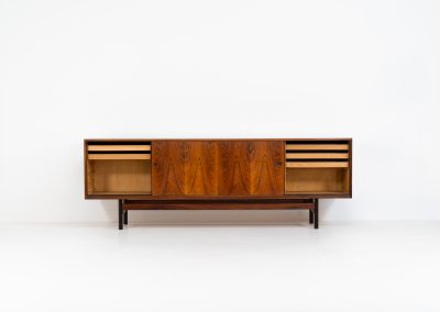 Rare XL sideboard in rosewood by Ib Kofod-Larsen for Faarup (Denmark, 1950s). This piece exudes pure luxury, featuring four large sliding doors with amazing inset handles and lots of storage space with adjustable drawers and shelves inside. The exterior is crafted from rosewood with a glossy finish, showcasing a stunning woodgrain, while the oak-finished interior provides a beautiful contrast. This hard to find piece presents itself in amazing vintage condition with minimal sings of a previous life. The doors slide really smooth. Marked by maker.